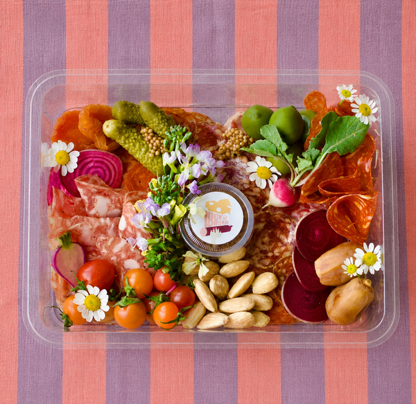 Lady & Larder charcuterie box of cured meats on pink striped background